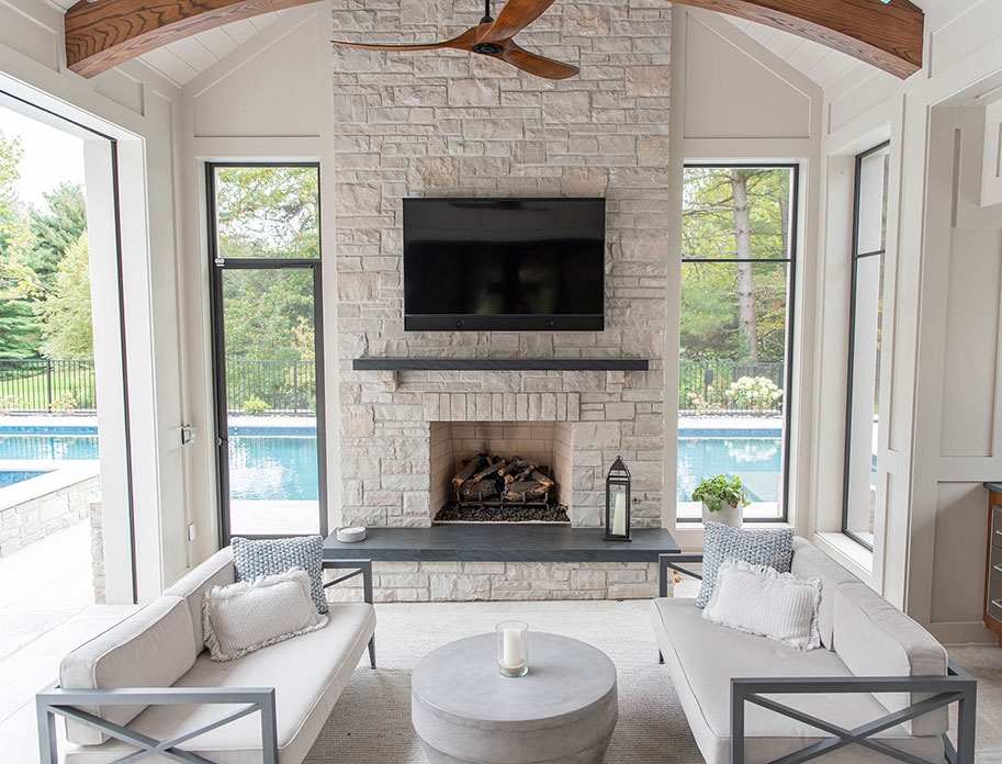 an interior living room space with large fireplace featuring fine Rademann Stone veneer