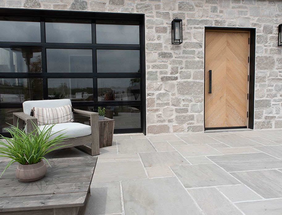 Close up of an exterior door and patio of a home with a fine Rademann Stone veneer.