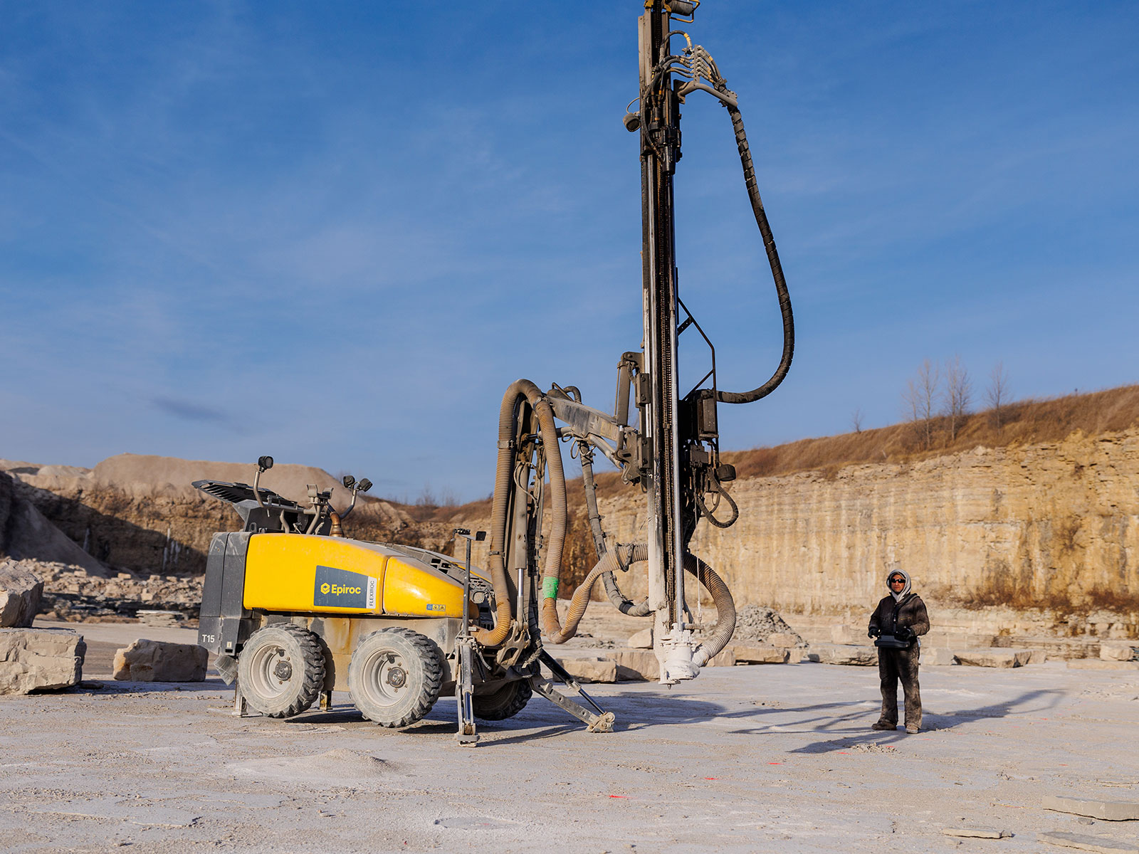A man remotely operating a machine in preparation for blasting stone in the Rademann quarry