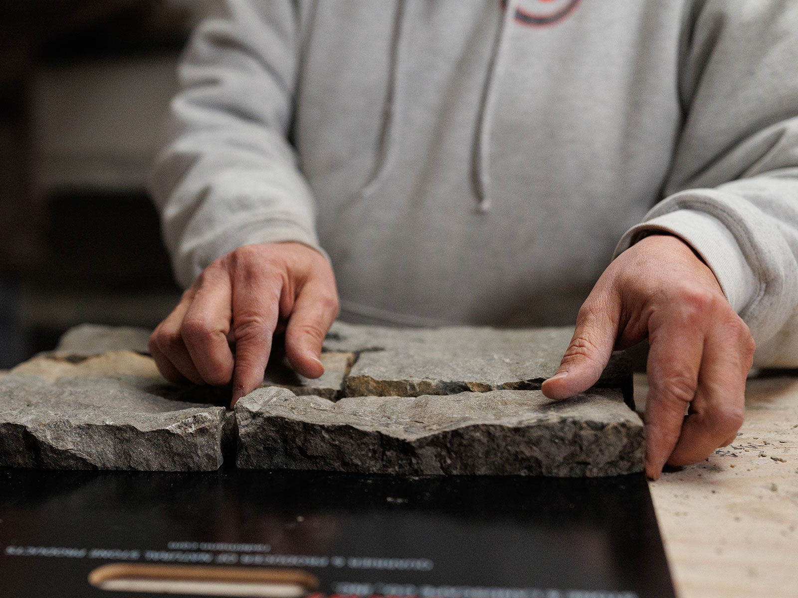 Close up of a man arranging a sample of Rademann stone veneer