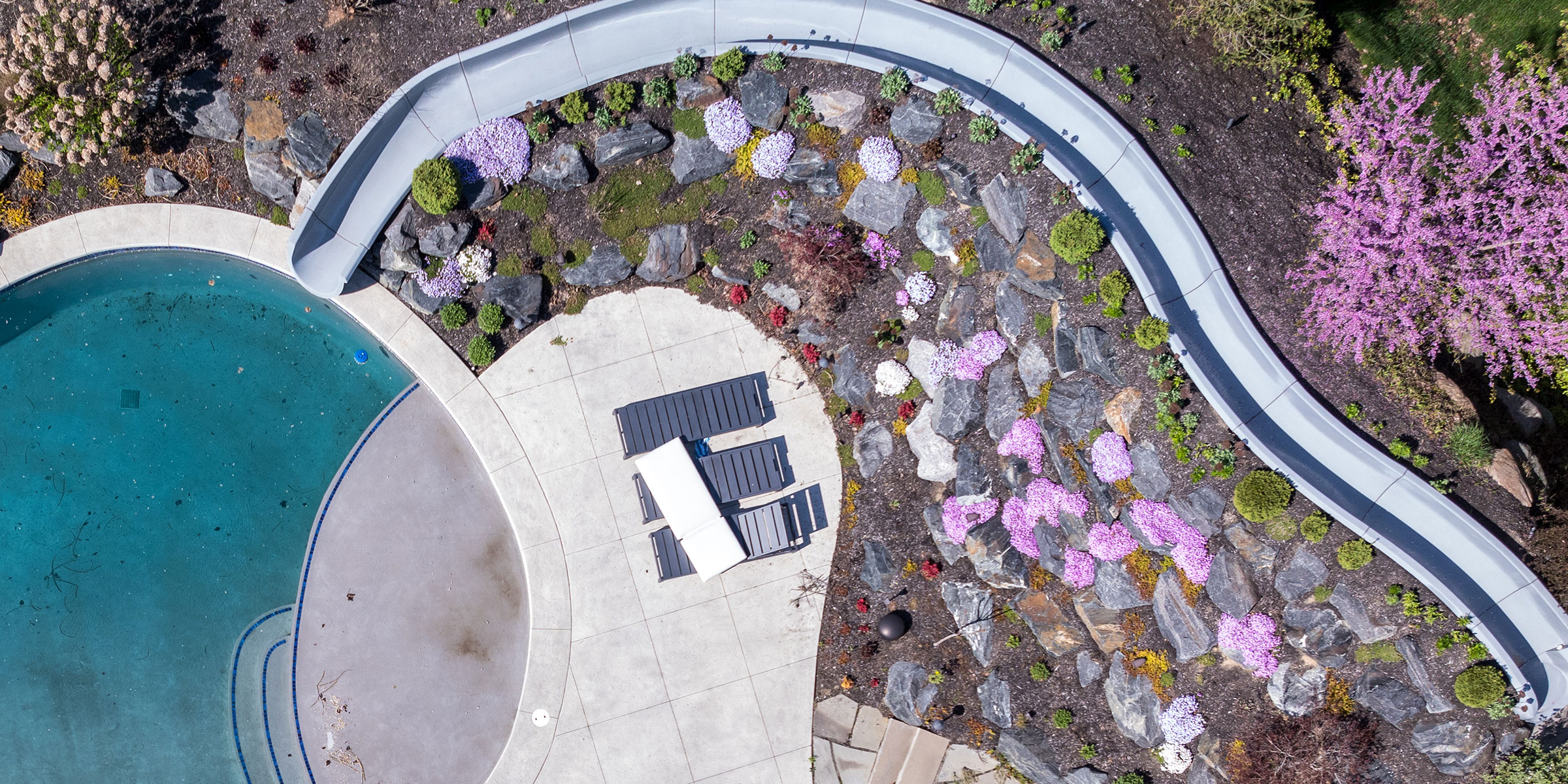 Overhead of an outdoor pool with Rademann Stone landscaped all around